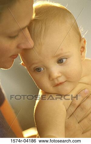 Stock Photograph - Close-up of mother holding her baby boy. Fotosearch