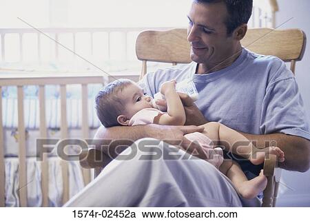Stock Image - Father feeding his baby boy. Fotosearch