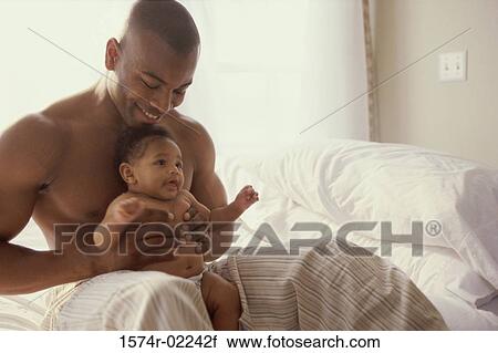 Stock Image - Father holding his baby boy. Fotosearch