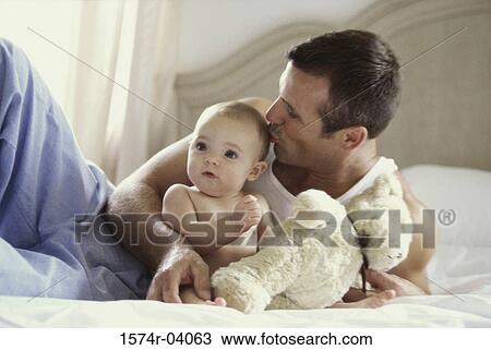 Stock Image - Father kissing his baby boy. Fotosearch
