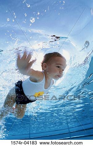 Stock Image - Girl swimming underwater. Fotosearch