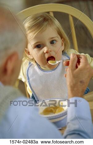 Grandfather feeding his granddaughter View Large Photo Image Stock Image - Grandfather feeding his granddaughter. Fotosearch