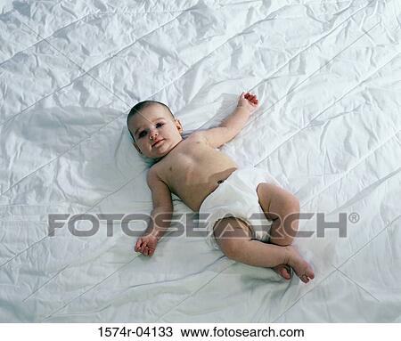 High angle view of a baby boy lying on a bed View Large Photo Image Stock Image - High angle view of a baby boy lying on a bed. Fotosearch