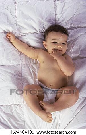 High angle view of a baby boy lying on a bed View Large Photo Image Stock Photography - High angle view of a baby boy lying on a bed. Fotosearch