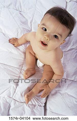 High angle view of a baby boy sitting on a bed View Large Photo Image Picture - High angle view of a baby boy sitting on a bed. Fotosearch