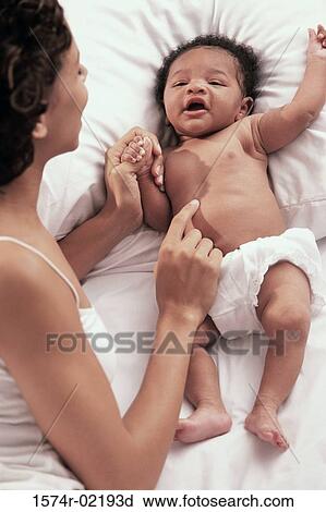 Stock Image - High angle view of a mother playing with her baby boy. Fotosearch