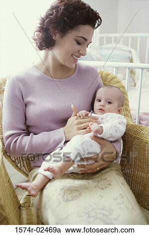 Stock Image - Mother carrying her baby girl. Fotosearch