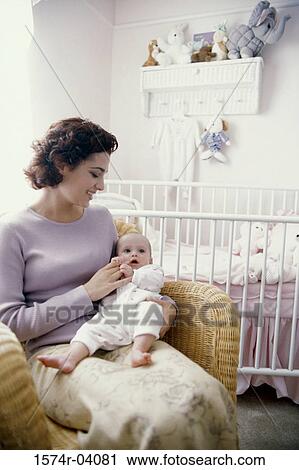 Mother sitting with her baby boy in nursery View Large Photo Image Stock Image - Mother sitting with her baby boy in nursery. Fotosearch