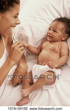 Stock Image - Mother touching her baby boy. Fotosearch