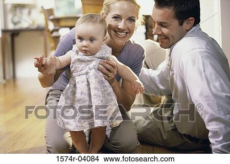 Picture - Parents helping their baby girl learn how to walk. Fotosearch