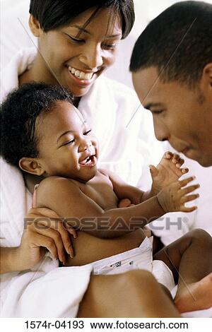 Stock Image - Parents playing with their baby boy. Fotosearch
