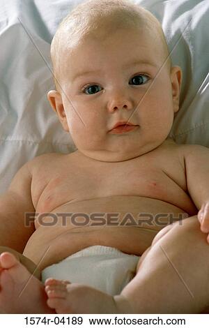 Portrait of a baby boy lying on a bed View Large Photo Image Stock Photo - Portrait of a baby boy lying on a bed. Fotosearch