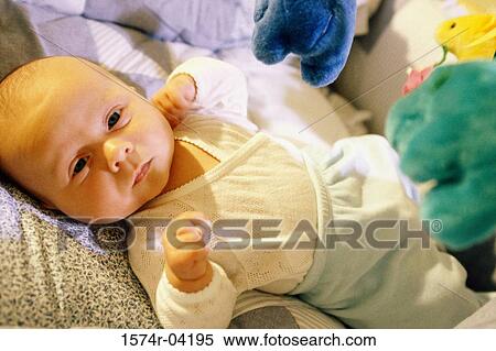 Stock Photography - Portrait of a baby boy lying on a bed. Fotosearch