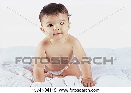 Portrait of a baby boy sitting on a bed View Large Photo Image Stock Image - Portrait of a baby boy sitting on a bed. Fotosearch