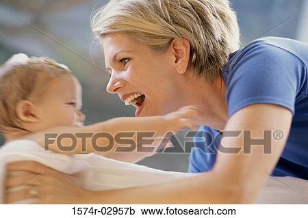 Stock Image - Side profile of a mother holding her baby boy. Fotosearch