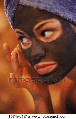 Close-up of a young woman applying a facial mask with her finger View Large Photo Image Stock Image - Close-up of a young woman applying a facial mask with her finger. Fotosearch
