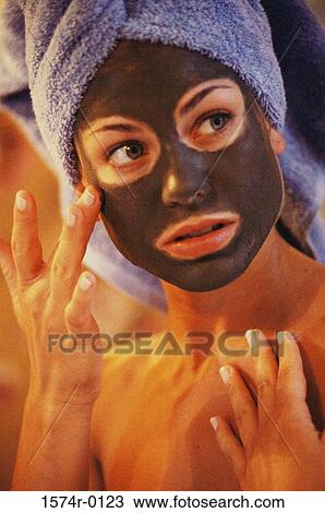 Close-up of a young woman applying a facial mask with her finger View Large Photo Image Stock Image - Close-up of a young woman applying a facial mask with her finger. Fotosearch