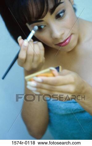 Close-up of a young woman applying eye shadow View Large Photo Image Stock Photo - Close-up of a young woman applying eye shadow. Fotosearch