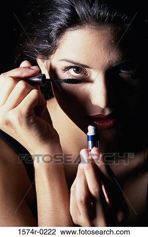 Stock Image - Close-up of a young woman applying mascara. Fotosearch