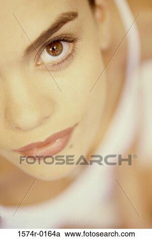 Stock Image - Close-up of a young woman looking at camera. Fotosearch