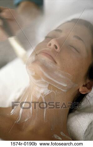 Person's hand applying a facial mask with a brush on a young woman's face View Large Photo Image Stock Image - Person's hand applying a facial mask with a brush on a young woman's face. Fotosearch