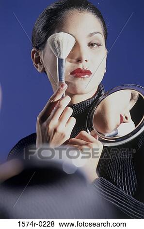 Portrait of a woman covering her eye with a makeup brush View Large Photo Image Stock Photo - Portrait of a woman covering her eye with a makeup brush. Fotosearch
