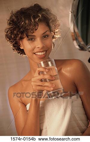 Portrait of a young woman holding a glass of water View Large Photo Image Stock Image - Portrait of a young woman holding a glass of water. Fotosearch
