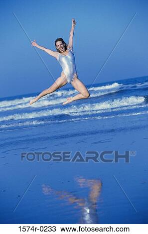 Portrait of a young woman jumping at the beach View Large Photo Image Stock Image - Portrait of a young woman jumping at the beach. Fotosearch