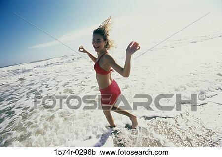 Portrait of a young woman running at the beach View Large Photo Image Stock Image - Portrait of a young woman running at the beach. Fotosearch