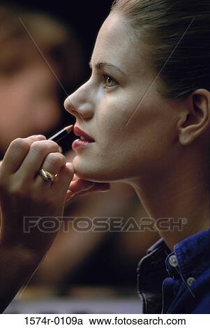 Side profile of a young woman applying lip liner View Large Photo Image Stock Image - Side profile of a young woman applying lip liner. Fotosearch