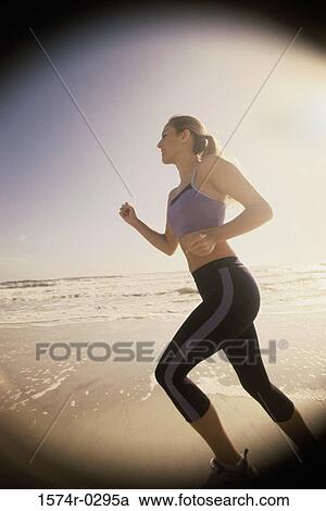 Side profile of a young woman jogging at the beach View Large Photo Image Stock Image - Side profile of a young woman jogging at the beach. Fotosearch