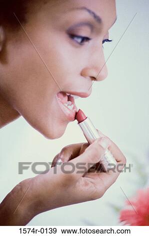 Woman applying lipstick View Large Photo Image Stock Photo - Woman applying lipstick. Fotosearch