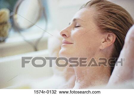 Woman lying with her eyes closed in a bubble bath View Large Photo Image Stock Image - Woman lying with her eyes closed in a bubble bath. Fotosearch
