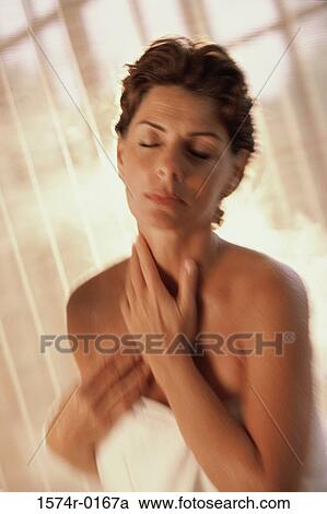 Stock Image - Woman standing with a towel wrapped around her. Fotosearch