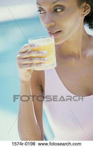 Stock Photo - Young woman drinking orange juice. Fotosearch