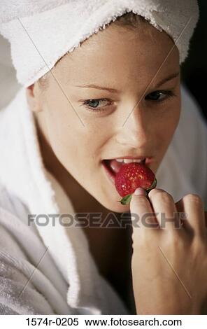 Young woman eating a strawberry View Large Photo Image Stock Photography - Young woman eating a strawberry. Fotosearch
