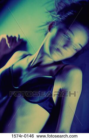 Young woman lying down wearing a bra View Large Photo Image Stock Photograph - Young woman lying down wearing a bra. Fotosearch