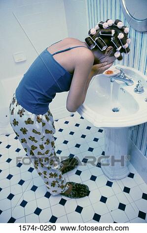Young woman washing her face in a washbasin View Large Photo Image Stock Image - Young woman washing her face in a washbasin. Fotosearch