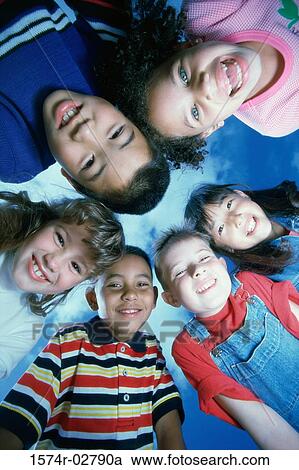 Stock Image - Close-up of a group of children in a huddle. Fotosearch