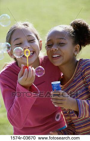 Close-up of two girls blowing bubbles View Large Photo Image Stock Image - Close-up of two girls blowing bubbles. Fotosearch