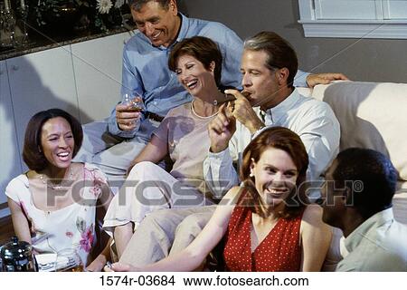Picture - Group of mid adult people sitting on a couch. Fotosearch