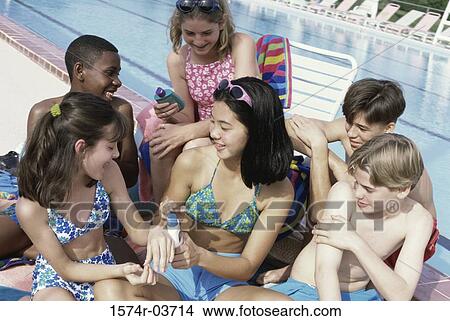 Group of teenagers sitting beside a swimming pool View Large Photo Image Picture - Group of teenagers sitting beside a swimming pool. Fotosearch