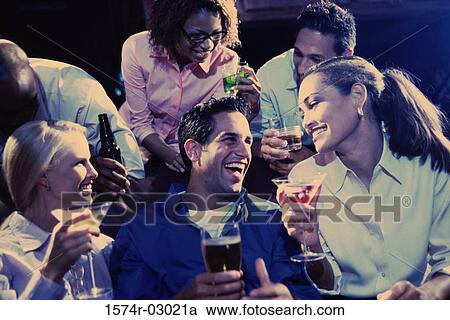 Stock Image - Group of young people in a bar. Fotosearch