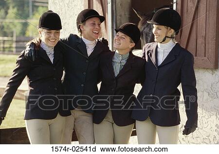 Stock Image - Group of young women standing together with arms around each other. Fotosearch