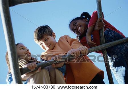 Low angle view of three children playing on a monkey bars View Large Photo Image Stock Image - Low angle view of three children playing on a monkey bars. Fotosearch