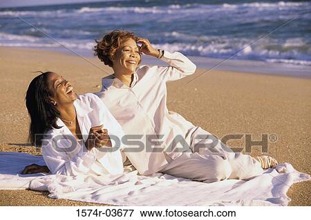 Stock Photo - Mother and her daughter lying on the beach. Fotosearch