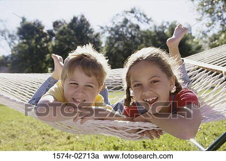 Portrait of a boy and a girl lying on a hammock View Large Photo Image Stock Image - Portrait of a boy and a girl lying on a hammock. Fotosearch