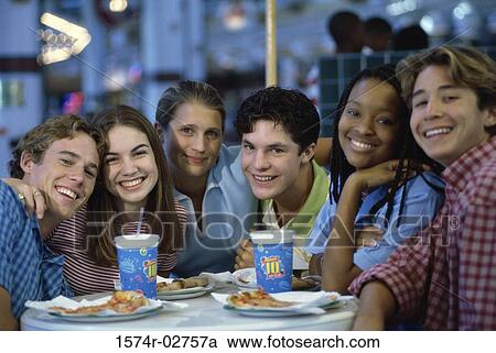 Stock Image - Portrait of a group of teenagers sitting in a restaurant. Fotosearch