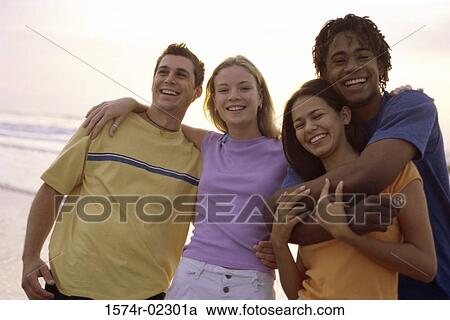 Stock Image - Portrait of two teenage couples on the beach. Fotosearch