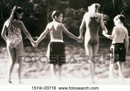 Stock Photograph - Rear view of a group of children holding hands. Fotosearch